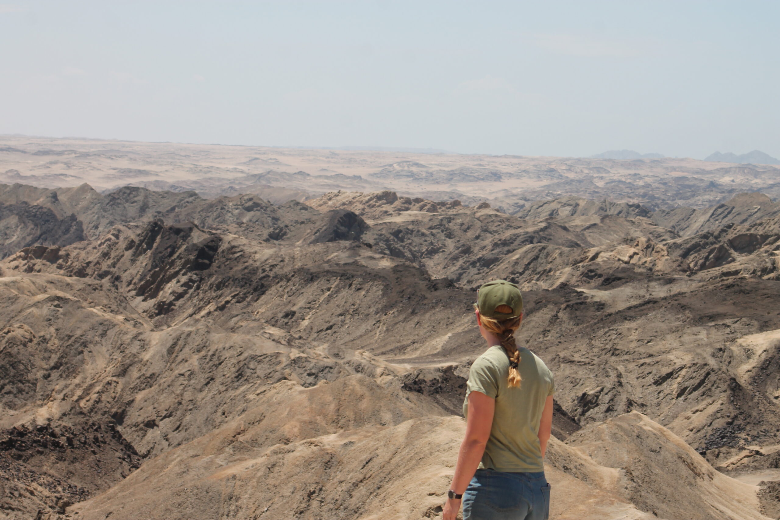 Aline du Plessis kijkt uit over een uitgestrekt woestijnlandschap in Namibië.